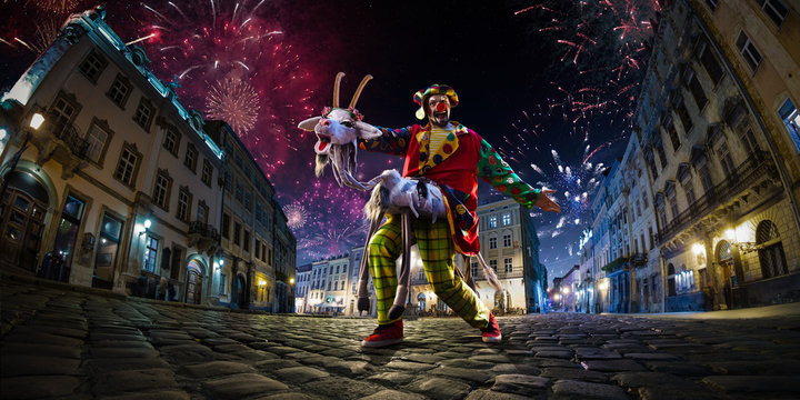 Night street circus performance whit clown, juggler. Festival city background. fireworks and Celebration atmosphere. Wide engle photo