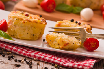 Potato gratins with mozzarella and tomatoes.