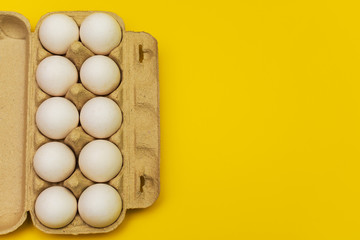 eggs in a cardboard box on a yellow background