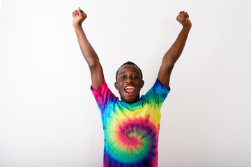 Studio shot of young happy black African man with both arms rais