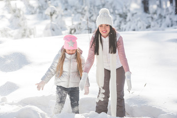 Fototapeta na wymiar Cheerful family having fun outdoors in winter