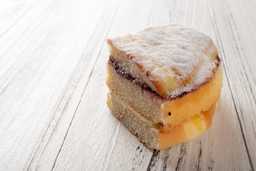 multi-layer sponge cake on white wood background