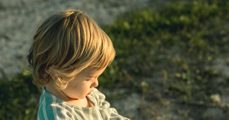 Portrait of a little blonde girl in the country with expression of happiness