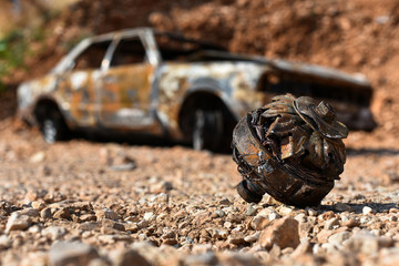 rusty burnt generator on the background of a burned-out car