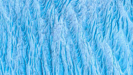 Beautiful glaciers flow through the mountains in Iceland. Aerial view and top view.