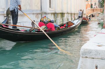 Fototapeta na wymiar Venice channel and gondolier with passengers