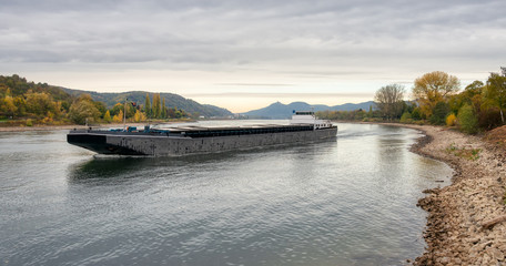 Vessel on river Rhine with low water level by Unkel with a view to Siebengebirge, Germany
