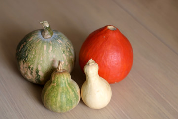 Various pumpkins on a wooden table. Selective focus.