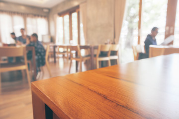 Restaurant interior with customer and wood table blur abstract background with bokeh light