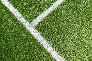 Green synthetic artificial grass soccer sports field with white corner stripe line