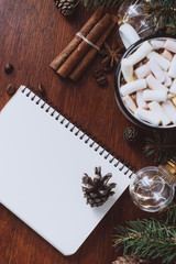 Chocolate or cocoa with marshmallow,  notebook and  garland on a wooden background.