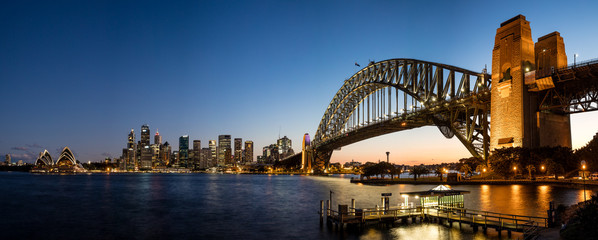 Blick auf den Hafen von Sydney auf das berühmte Opernhaus und die Hafenbrücke von Sydney in der Abenddämmerung