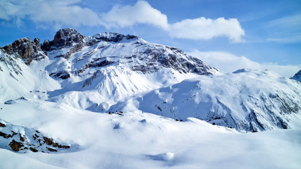 Fototapeta na wymiar Alpine snowy peaks panorama with slopes, off piste on fresh powder in 3 Valleys winter sport resort, Alps, France, on a sunny cold day .