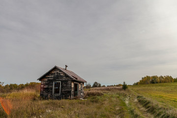 neglected cabin in a farmers field