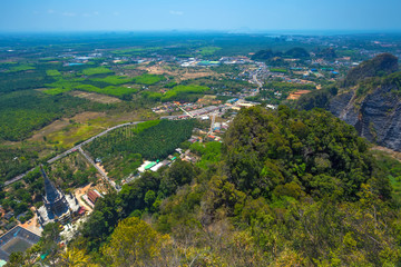Panoramic view from the top of the mountain to the neighborhood, green fields, forests, road, houses from a bird's flight. Tham Sua Thamsua Cave Temple Enlightenment Center, Krabi, Thailand.