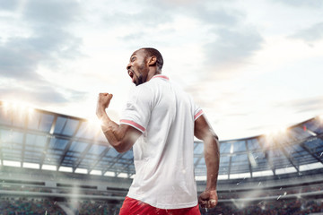 The football african player in motion on the field of stadium at day. The professional football,...