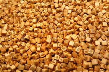 Fototapeta premium Amber texture. Processing technology of amber. Polishing pieces of resin and peeling off pieces of wood. Wooden cubes with polishing paste and amber. Solar stone. Background for advertising jewelry