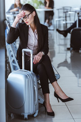 exhausted businesswoman sitting in departure lounge at airport