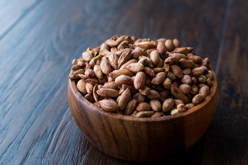 Organic Pistachio Nuts Without Shell in Wooden Bowl.