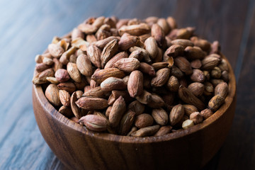 Organic Pistachio Nuts Without Shell in Wooden Bowl.