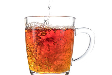 Brewing a tea bag in a transparent mug with sugar on a white background, a storm in a glass