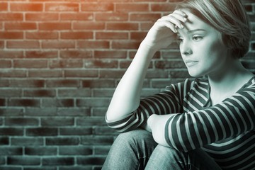 Young depressed woman on blurred background