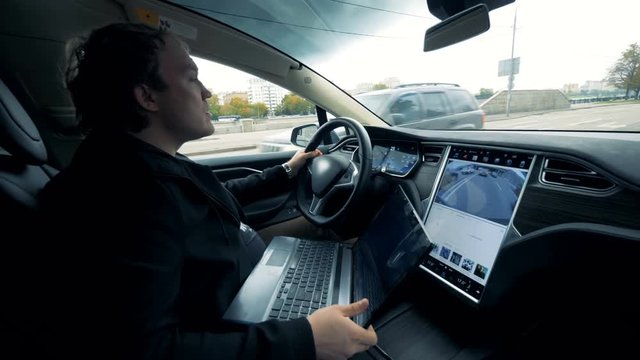 A man rides an electromobile on the road. Futuristic automated electric car self driving.