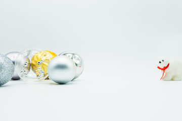 Silver, transparent and golden christmas balls on white with polar bear toy.