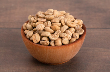 Bowl of Raw Green Coffee Beans on a Wooden Table