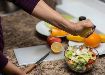 Female hand cuts vegetables for salad.