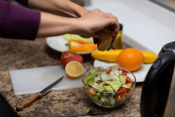 Female hand cuts vegetables for salad.