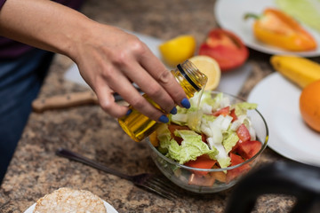 Female hand cuts vegetables for salad.