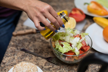 Female hand cuts vegetables for salad.