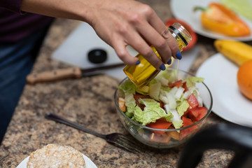 Female hand cuts vegetables for salad.