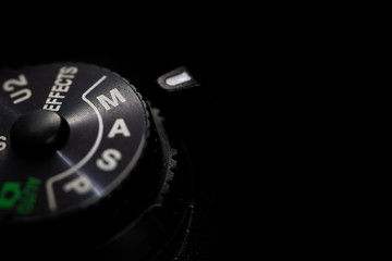 Close-up macro shot of a modern digital SLR camera with the dial in Manual Mode