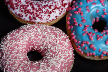 Three donuts on a black dish