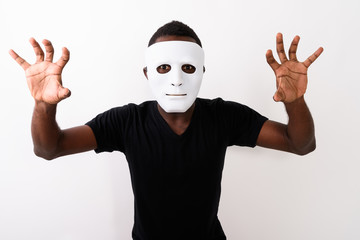 Studio shot of young black African man wearing mask and showing 