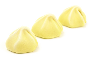 Line of Three Yellow Meringues on a White Background