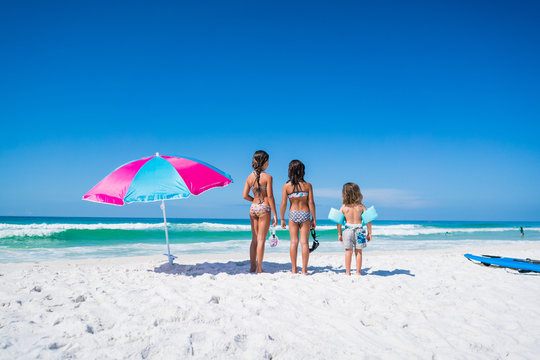 Three Kids on the Beach with an Umbrella