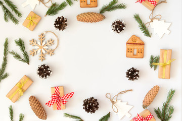 Christmas composition. Frame made of white and wood decor, cones, branches, cookies on white. Flat lay, copy space