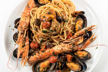 Plate of spaghetti with prawn mussels olives and tomatoes
