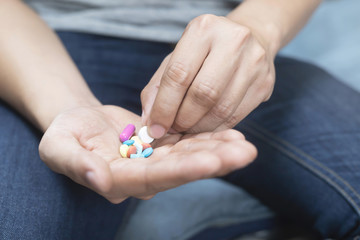 close up hand man taking multiple colors pills take a medicine. Stop drug use Taking Medication health care medical concept	