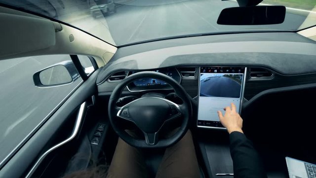 Person controls a self-driving car. Autonomous autopilot driverless car