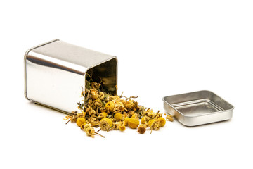 Isolated dried chamomile tea herbal infusion from a metal tin container
