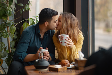 Young couple in love sitting in a cafe, drinking coffee