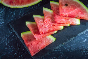 Sliced watermelon on dark chalk board