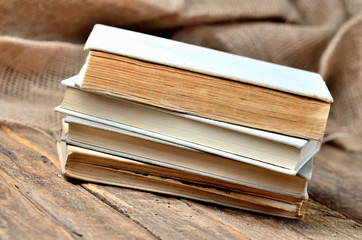 Stack of old, vintage books from the antiquarian bookshop on a rustic wooden table