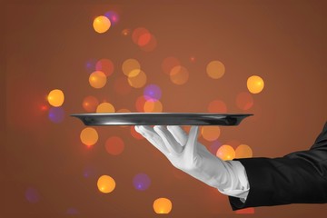 Elegant waiter hand in white glove holding an empty plate