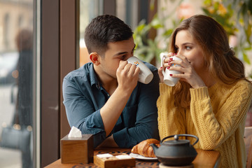 Young couple in love sitting in a cafe, drinking coffee