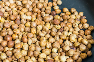 fry hazelnuts in a frying pan. fresh nuts in the pan.